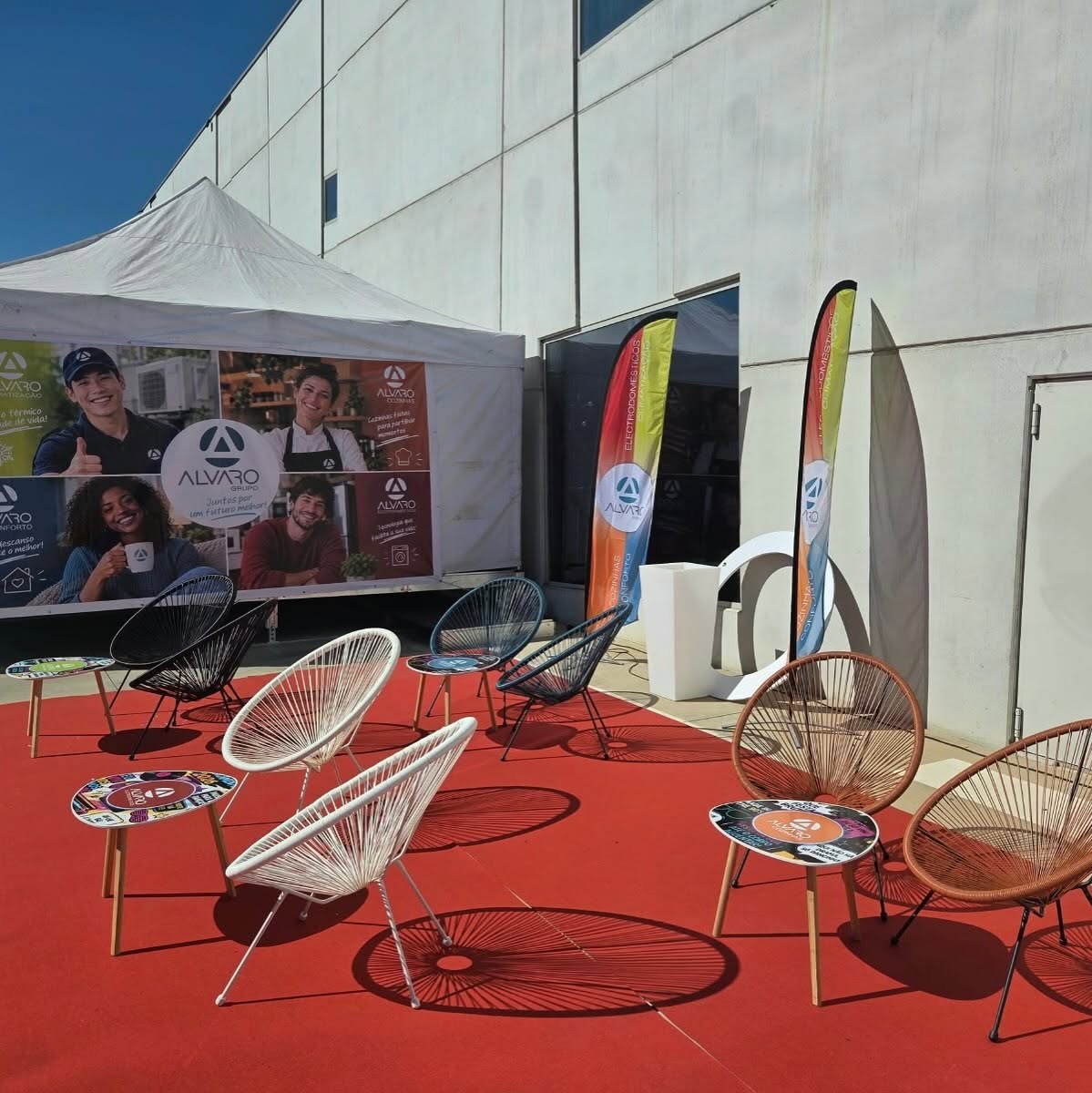 Espaço da Álvaro num evento, com tenda, bandeiras e cadeiras